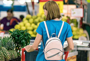 femme qui fait ses courses dans un supermarché avec un caddie